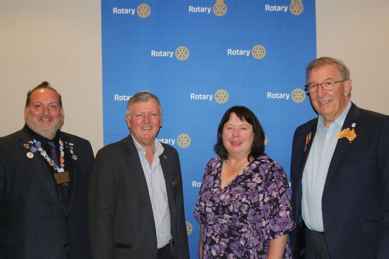 Club members at a Rotary event backdrop